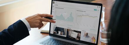 EWE Business Portal Eine Person erklärt Diagramme auf einem Laptop
