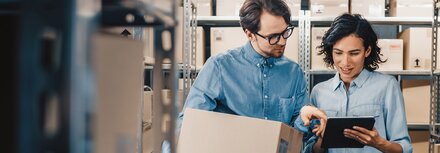 EWE business Gas logic spot Eine Frau und ein Mann in einem Lagerraum, die etwas auf einem Tablet prüfen