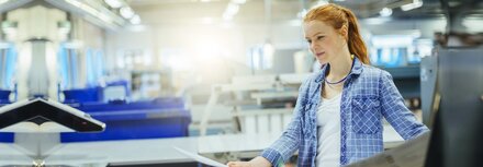 Eine Frau, die einen Proof in einer Druckerei prüft