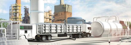 Ein LKW mit Rohrleitungen vor einer Fabrik mit Wasserstofftank und Elektrolyseur, im Vordergrund PV-Module