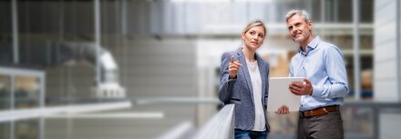 Eine Frau und ein Mann mit Tablet in einer Werkshalle