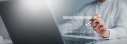 Jetzt Termin für eine Energieberatung buchen Eine Person im weißen Hemd vor einem Holo-Kalender über einem Laptop