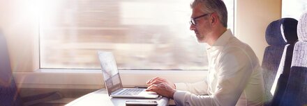 Cloud PBX von EWE Mann im Zug am Laptop