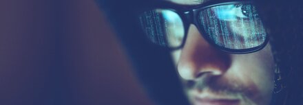 IT-Security Stilisierter Hacker blickt in die Kamera