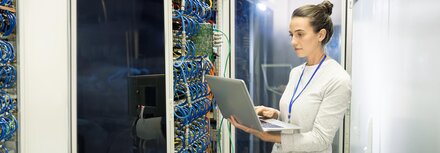 Carrier-Dienste von EWE Eine IT-Expertin mit Laptop vor einem Server