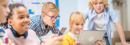 Engagierte Schülerinnen und Schüler vor einem digitalen Arbeitsplatz