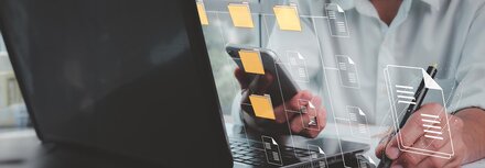 IT-Sicherheit Ein Mann vor einem Notebook, "in der Luft" verbundene Ordner-Icons