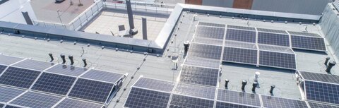 PV-Energie als Hebel für die Effizienzoptimierung von Unternehmen Solarpaneele auf einem Gebäude aus der Luft
