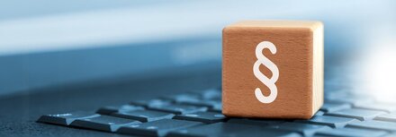 Gesetzesänderungen 2025 Ein Holzwürfel mit Paragraphenzeichen auf einer Tastatur
