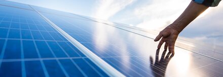 PV-Pflicht in Niedersachsen Ein Hand, die eine PV-Fläche berührt