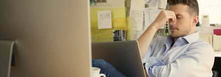 Cyberkriminalität: Die Gefahr aus dem Netz wächst Ein Mann sitzt am Schreibtisch vor einem Monitor in einem Büro ärgert sich über einen erfolgreichen Hackerangriff auf sein Unternehmen