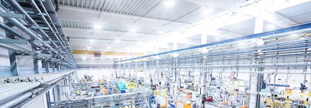 Beleuchtungsaustausch clever finanzieren Neue Industriemaschinen in einer modern beleuchteten Produktionshalle.
