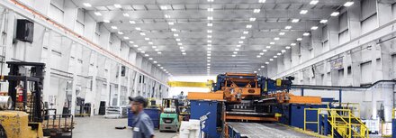 Modernisieren mit LED-Sanierungslichtträgern Hell ausgeleuchtete Produktionshalle mit moderner Deckenbeleuchtung