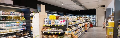 Präsentation durch Licht im Einzelhandel Supermarkt mit professionell ausgeleuchteten Regalen und Auslagen.