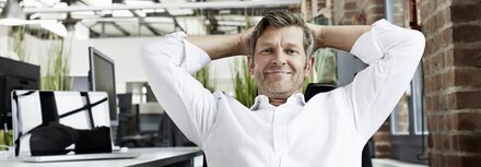 10 Fakten zu Wärme Contracting Mann sitzt entspannt in einem Bürostuhl im Büro