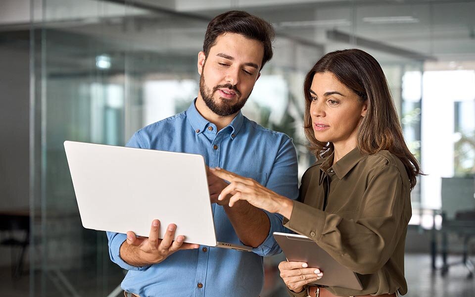 Eine Frau und ein Mann, die auf einem Tablet etwas ansehen