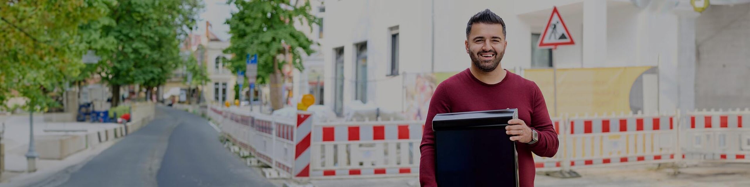 Ismet Kolcu mit PV-Modul in einer Straße mit Baustlele