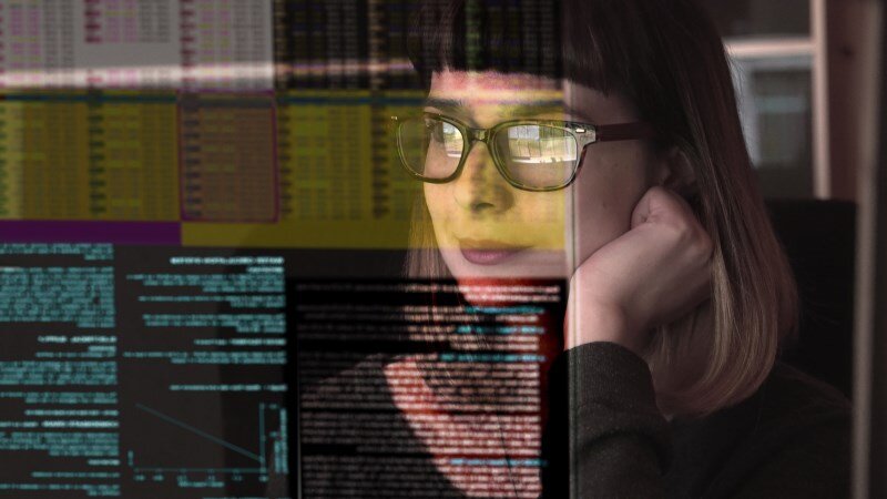 Eine Frau guckt auf einen Bildschirm mit vielen Zahlen