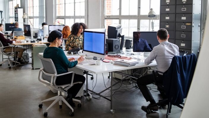Menschen in einem Startup-Büro nutzen schnelles Glasfaser bei der Arbeit.