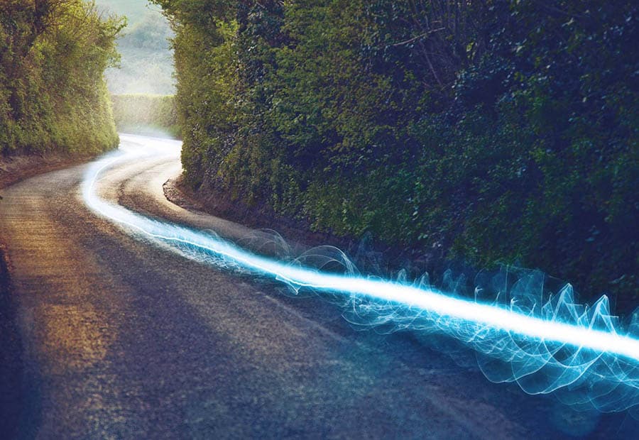 Eine stilisierte hellblau leuchtende Datenspur auf einem Weg