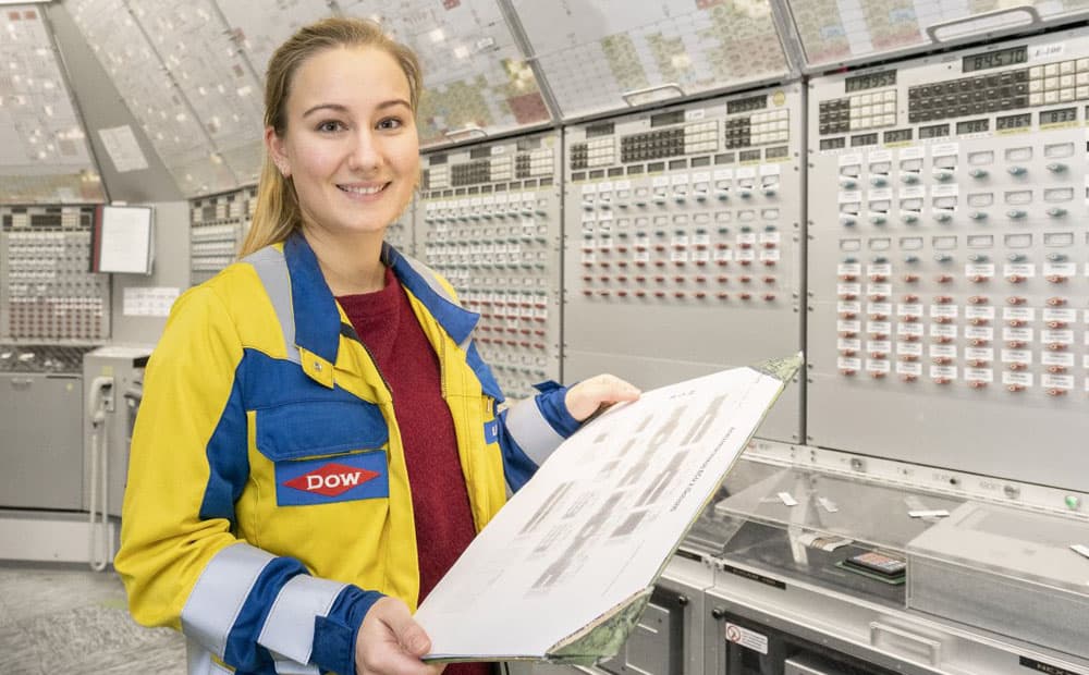 Eine Mitarbeiterin in Arbeitsjacke mit Plan in einem Dow-Kontrollraum