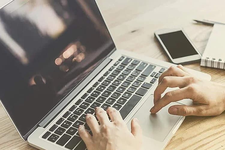 Hände tippen auf Laptoptastatur