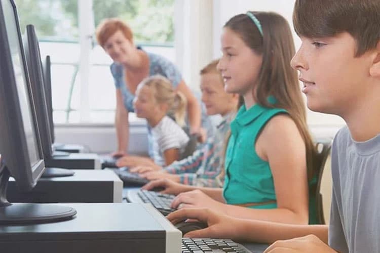 Jugendliche vor Computern in der Schule