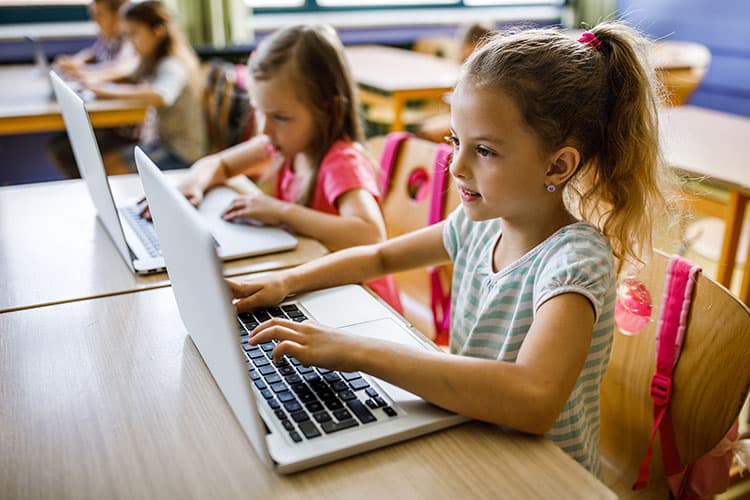 Kinder in einer Klasse vor Computern