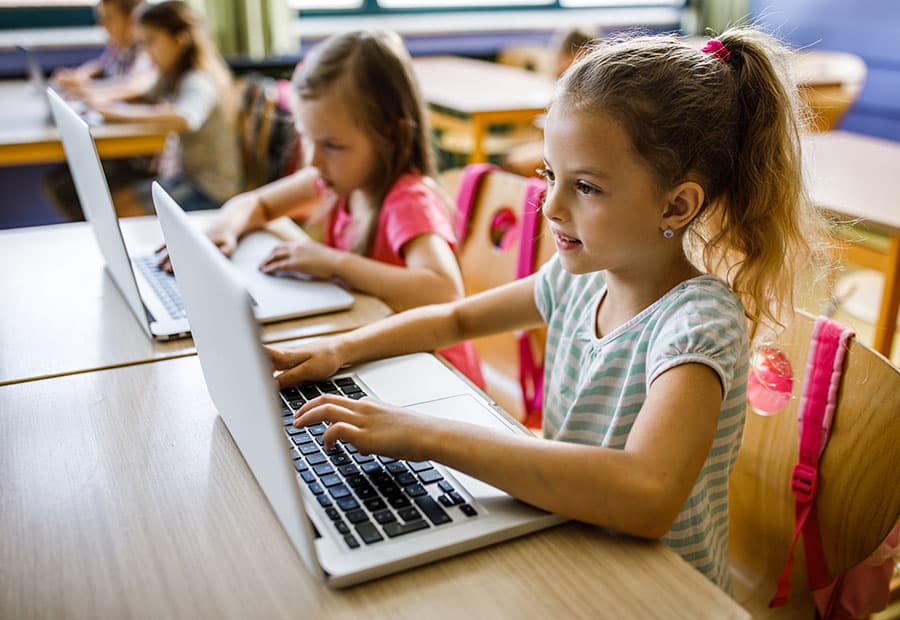 Kinder in einer Klasse vor Computern