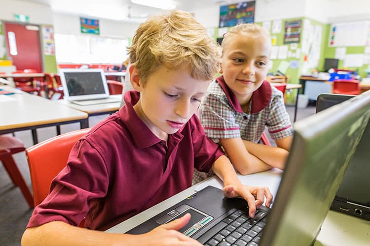 Ein Junge und ein Mädchen vor einem Schulcomputer