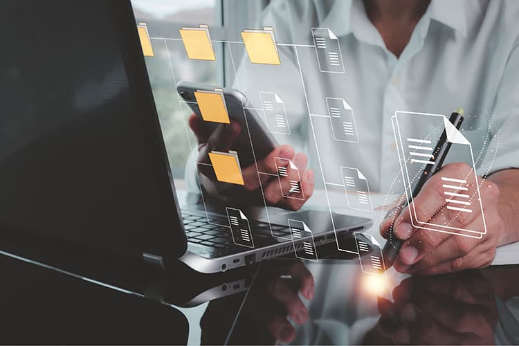 Ein Mann vor einem Notebook, "in der Luft" verbundene Ordner-Icons