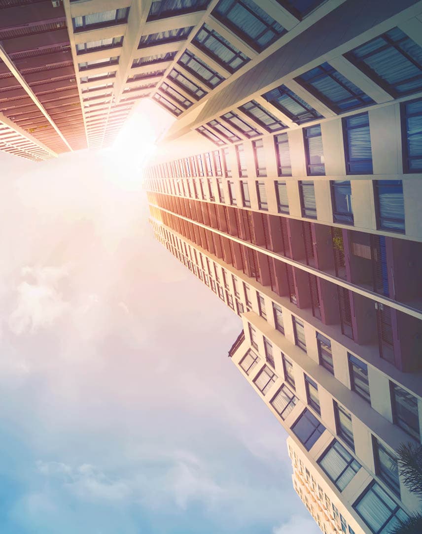 Eine sonnendurchflutete Häuserschlucht von unten