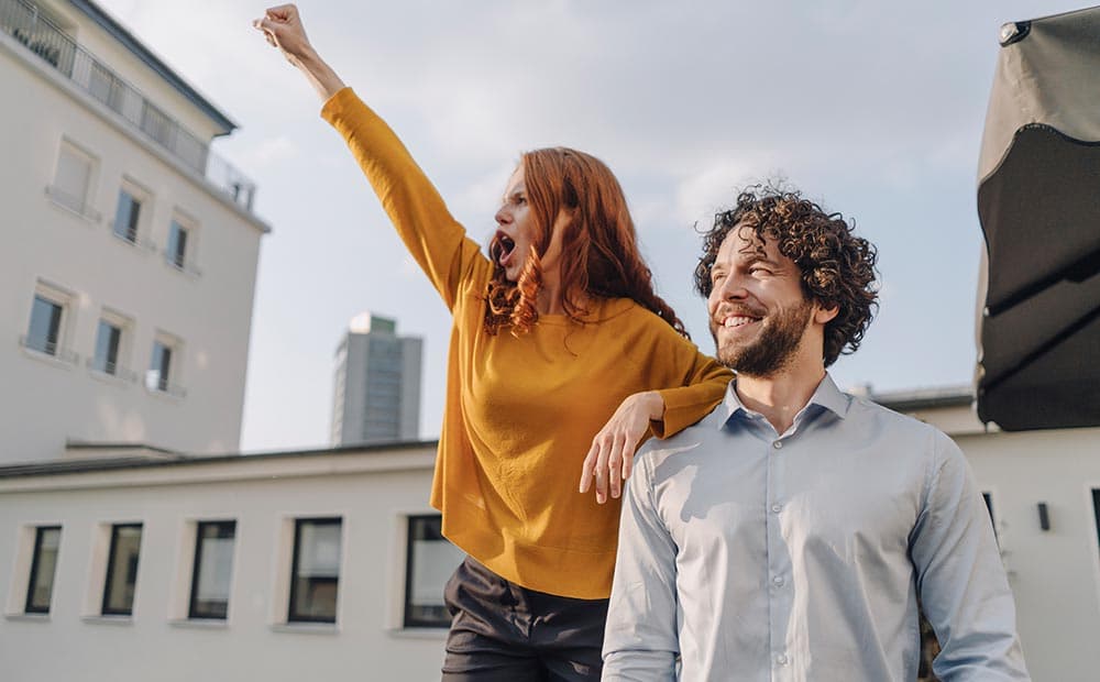 Eine Frau reckt die Faust, daneben ein Mann, beide freuen sich