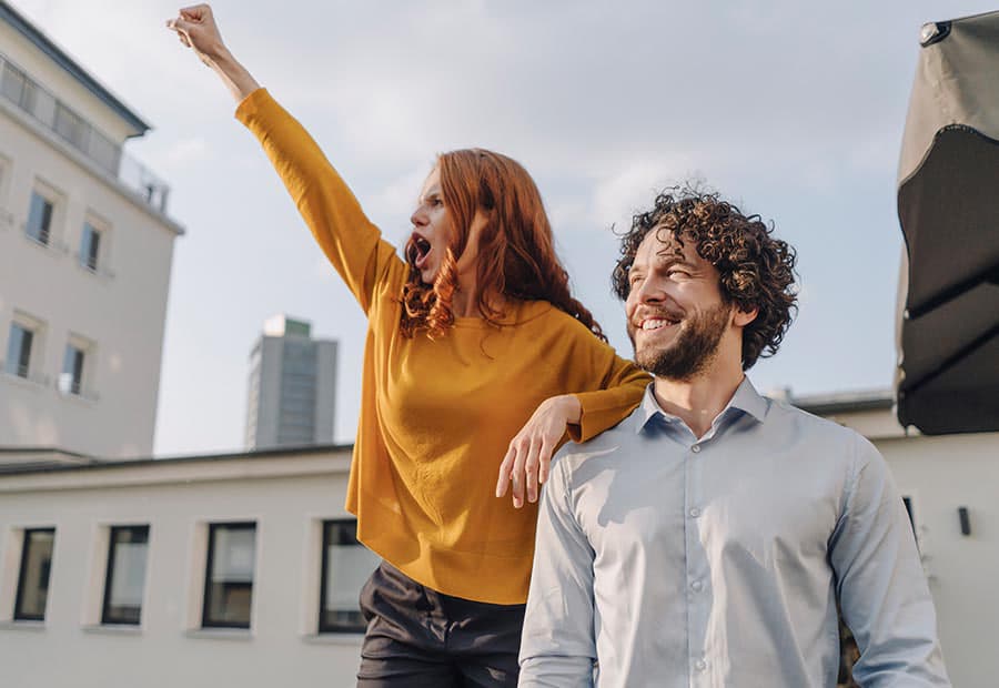 Eine Frau reckt die Faust, daneben ein Mann, beide freuen sich