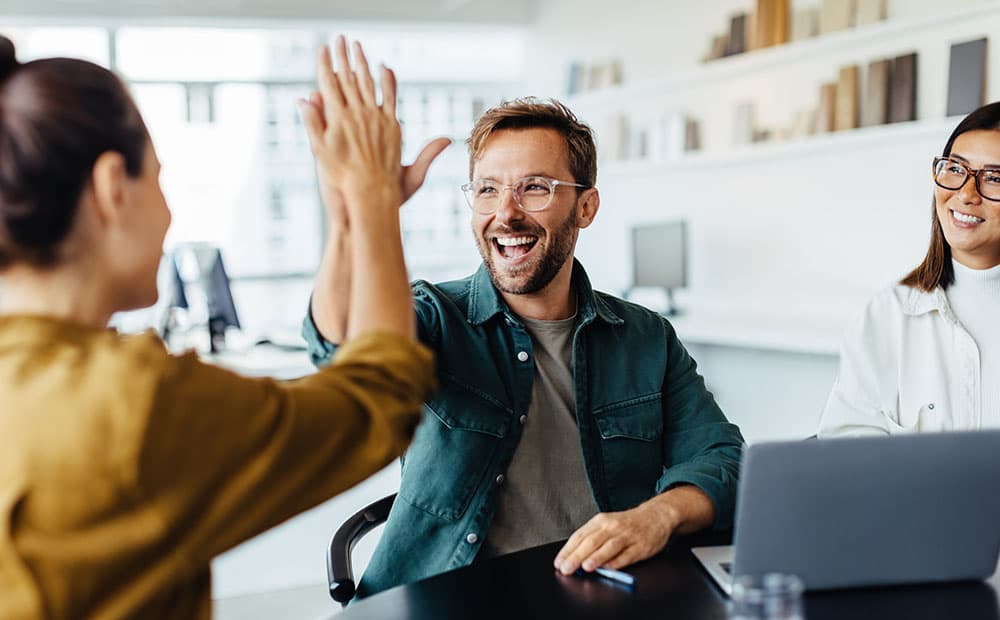 Eine Frau und ein Mann, die sich im Büro abklatschen