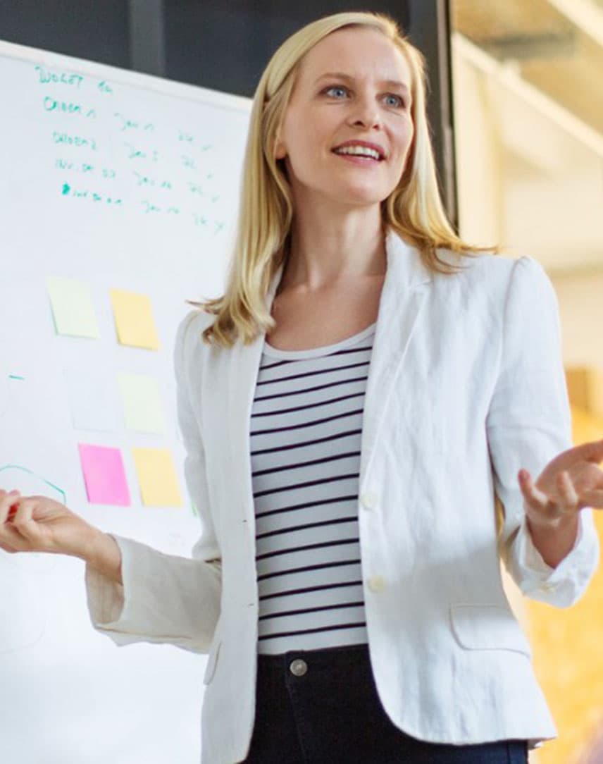 Eine Frau hält einen Vortrag vor einem Flipchart.