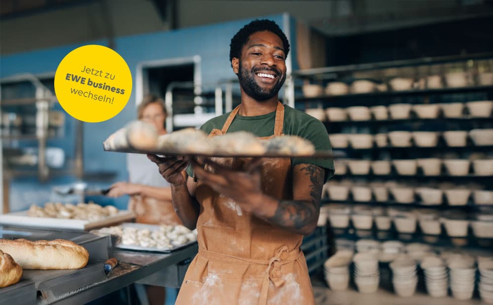 Ein Bäcker mit Tablett in der Backstube