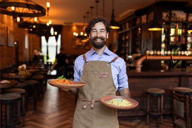 Ein Restaurantmitarbeiter mit Pastatellern