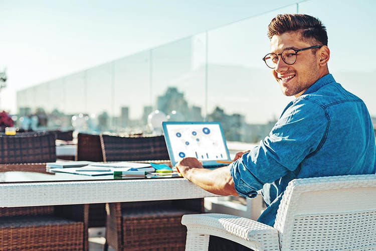 Eine Frau und ein Mann in Business-Kleidung besprechen etwas bei einer Veranstaltung an einem Stehtisch.