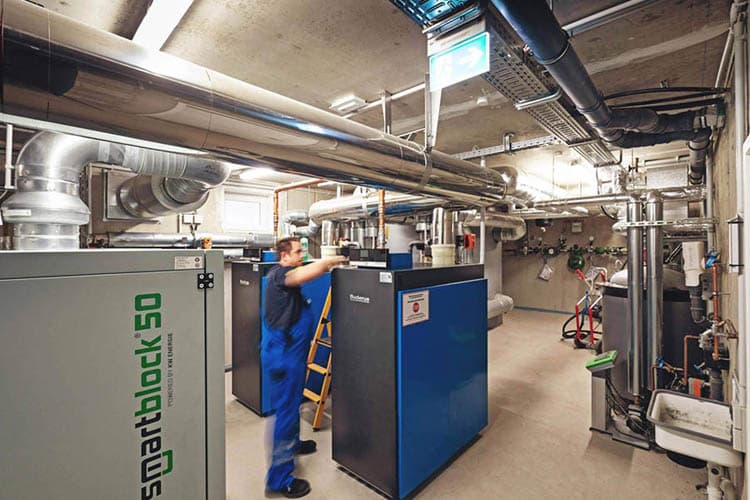 Ein Techniker, der im Keller an einer Heizungsanlage arbeitet