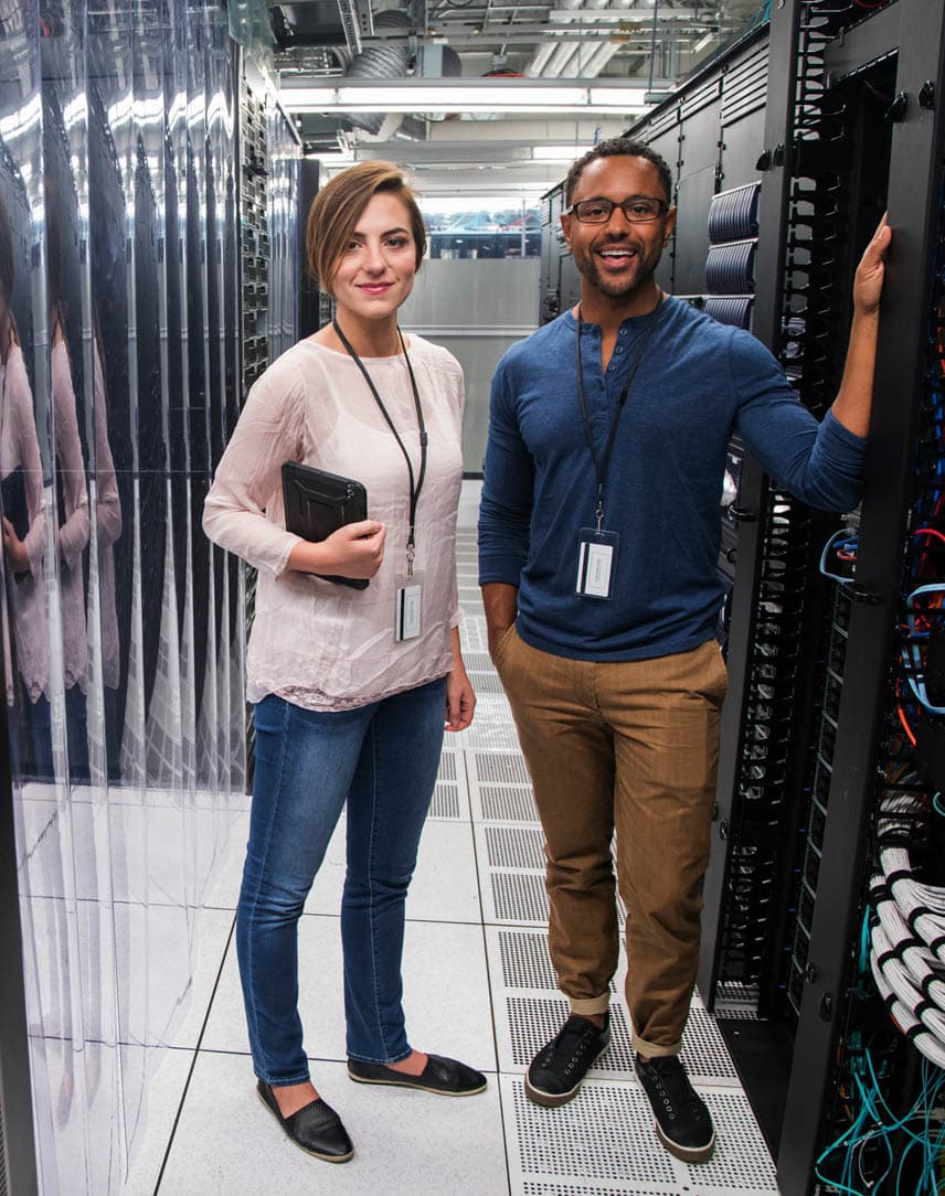 Eine Frau und ein Mann stehen in einem Serverraum.