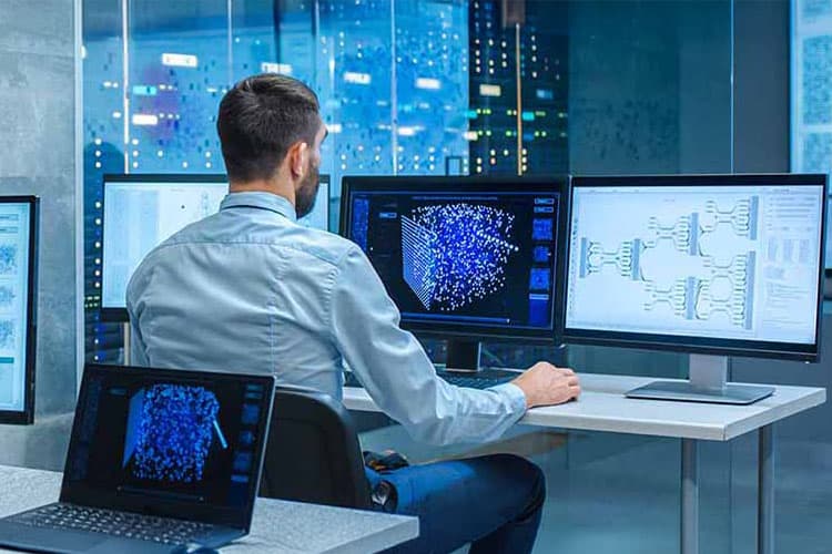 Ein Mann an einem Schreibtisch in einem Raum mit Computer-Bildschirmen