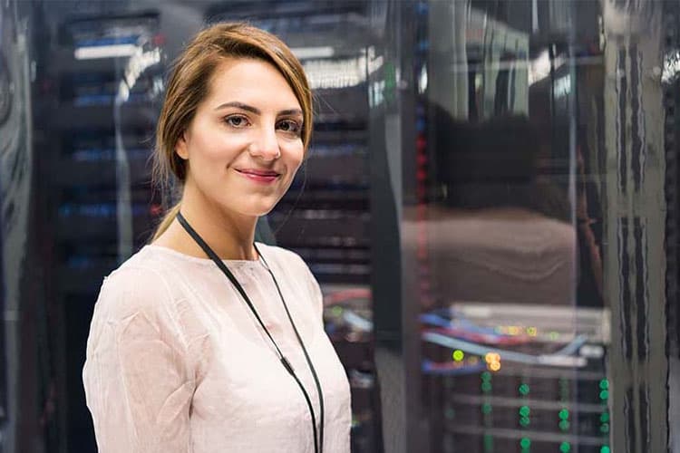 Eine lächelnde Frau in einem Serverraum