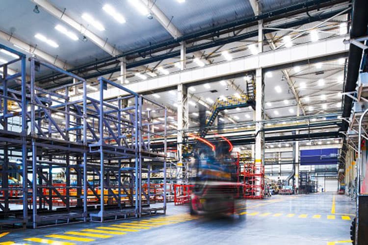 Eine hell erleuchtete Industriehalle mit Gabelstaplern und Regalen