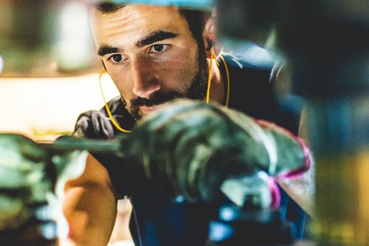 Ein Mann arbeitet konzentriert in einer Produktionshalle