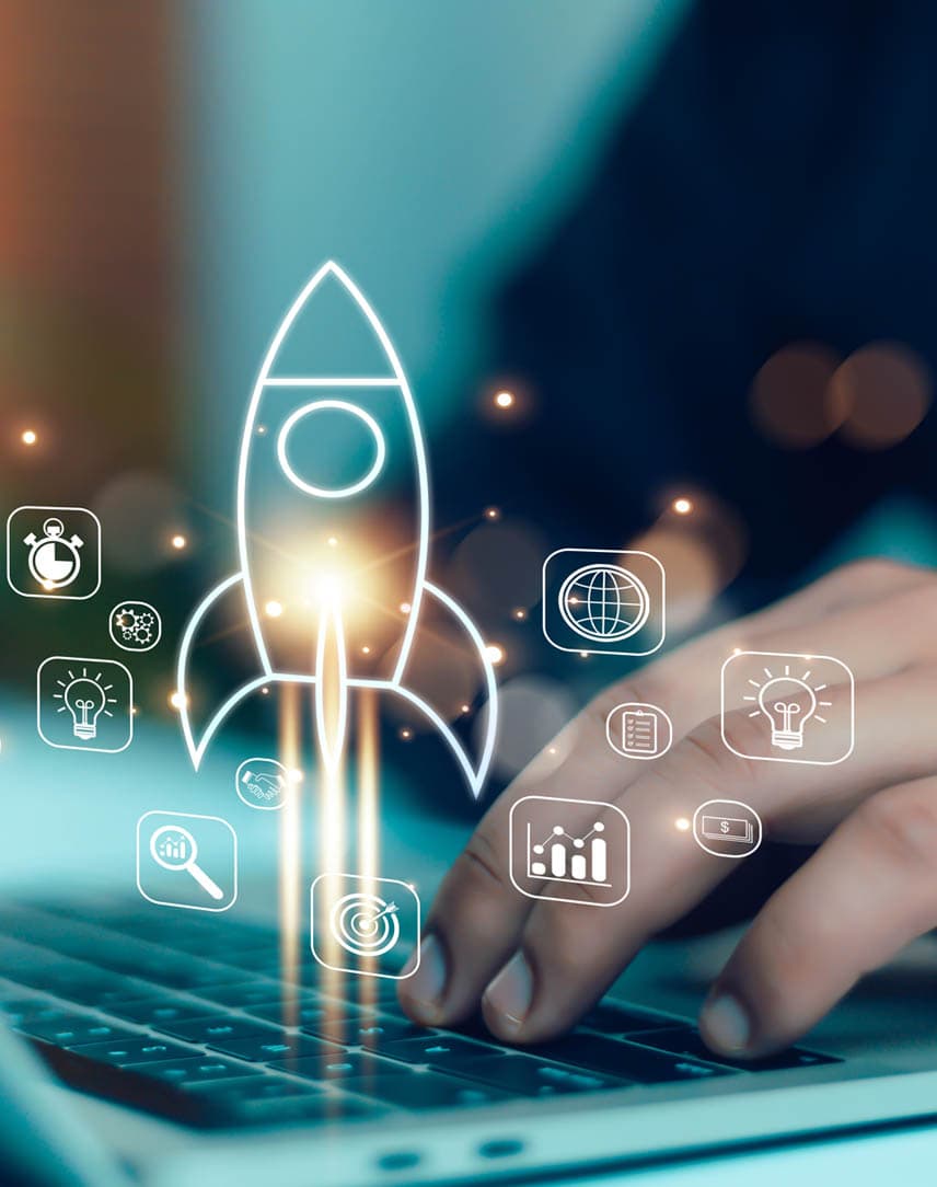 Eine Person arbeitet an einem Laptop, darauf ist das Icon einer startenden Rakete sowie andere kleinere Icons zu sehen, die zur digitalen Arbeit passen.