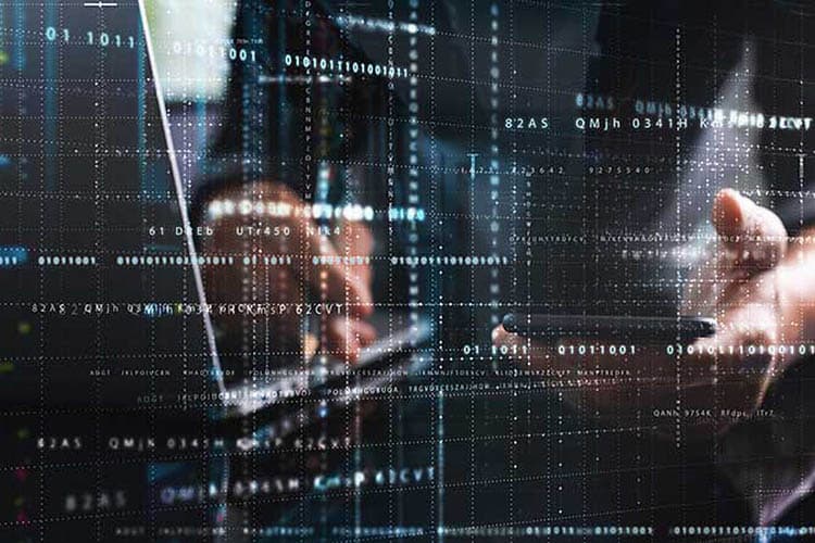 Eine Person arbeitet an Laptop und Handy, nur die Hände sind zu sehen, im Vordergrund stilisierte IT-Prozesse mit Linien und Zahlen