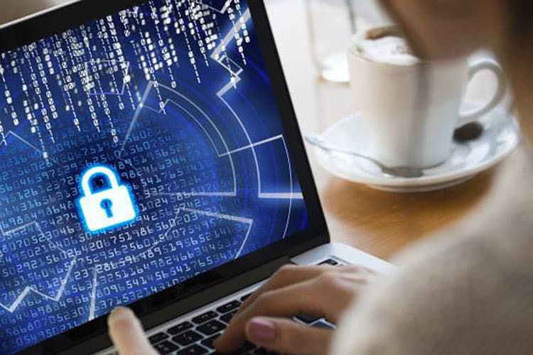 Eine Frau sitzt vor einem Rechner, der durch einen Ransomware Angriff gesperrt wurde.