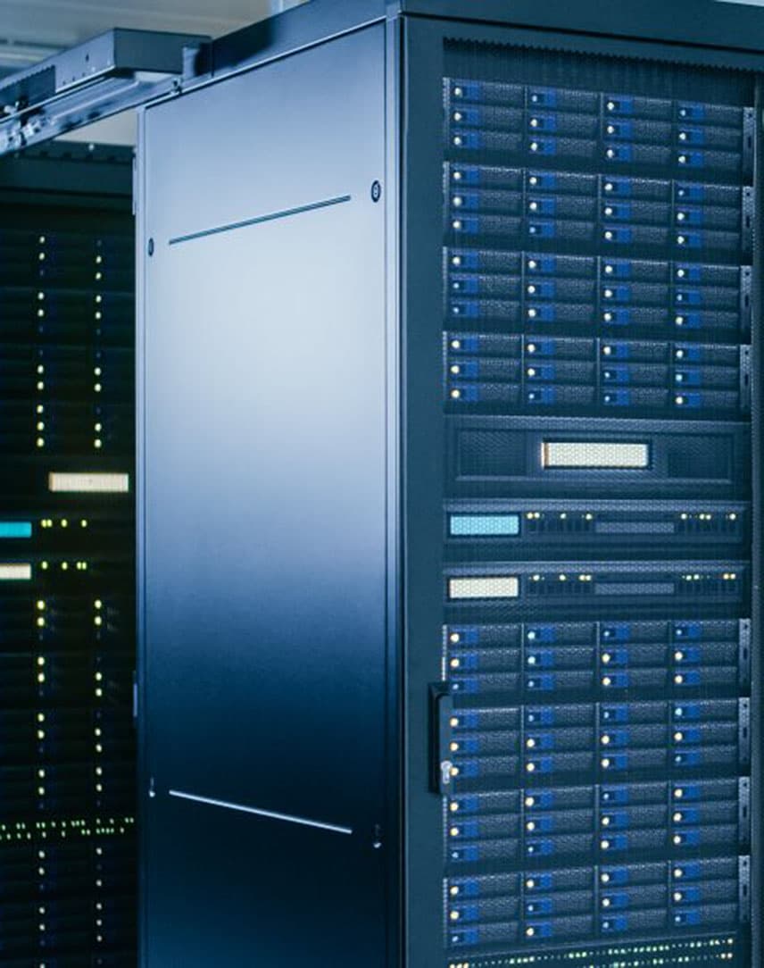 In einem hellen Raum stehen dunkle IT-Serverschränke in mehreren Reihen aneinandergereiht.