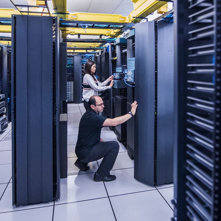 Zwei TechnikerInnen bei der Arbeit in einem Rechenzentrum